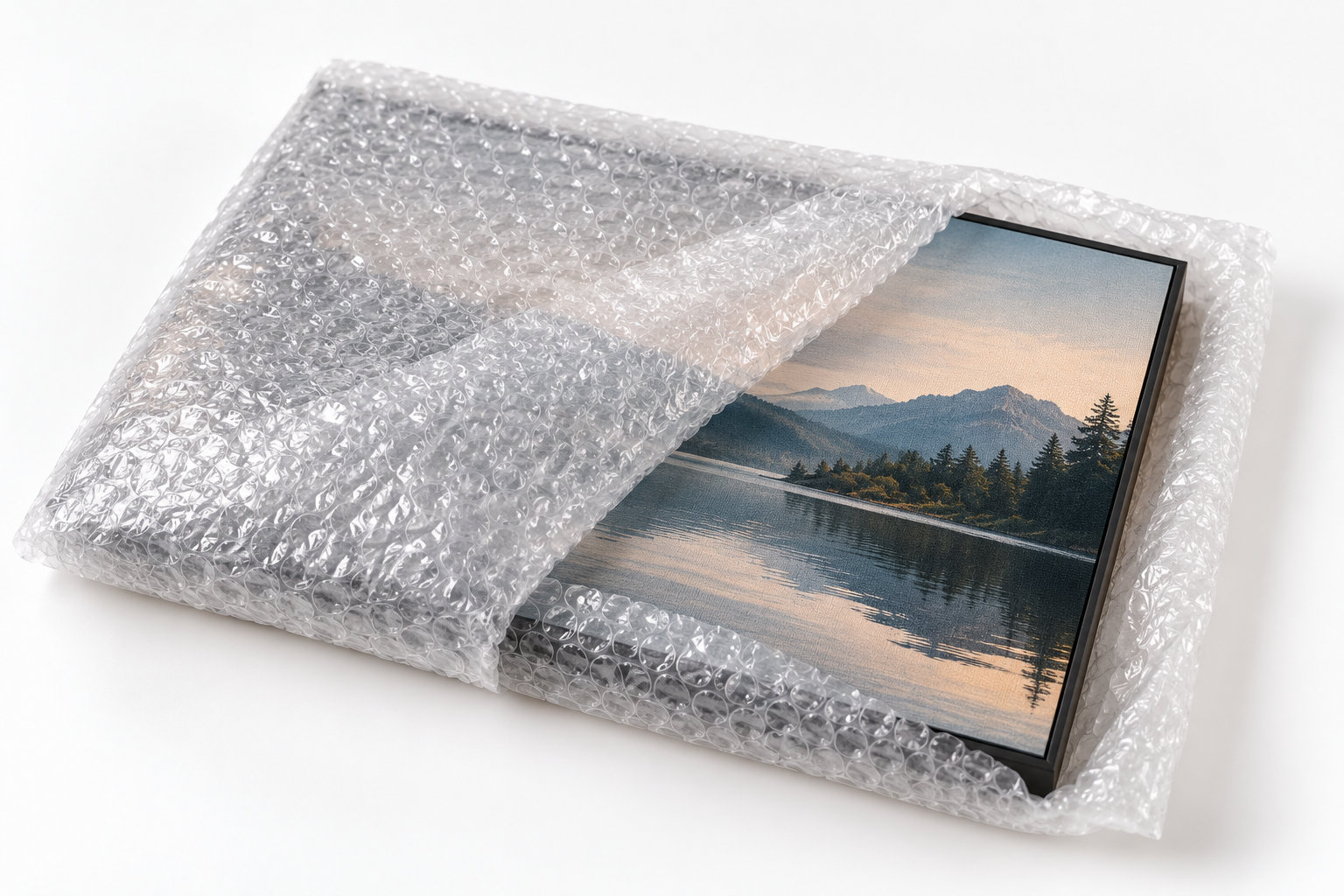 Framed landscape print partially wrapped in bubble film